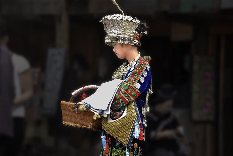 刚表演完节目,接着又要向游客推销工艺品.  拍摄地点: 雷山县朗德