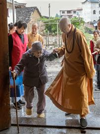 搀扶百岁老人的寺庙主持